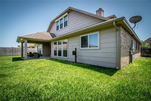 back of property featuring a lawn and a patio