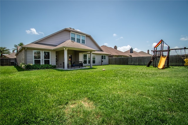 back of house with a lawn, a playground, and a patio