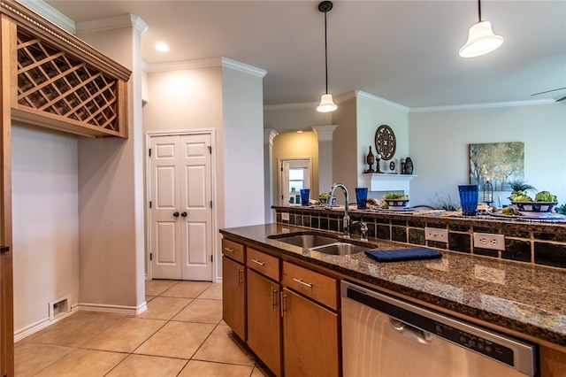 kitchen with crown molding, decorative light fixtures, sink, dark stone countertops, and stainless steel dishwasher