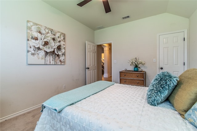 carpeted bedroom with ceiling fan, ornate columns, and vaulted ceiling