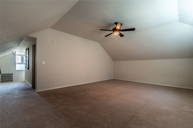 additional living space with ceiling fan, vaulted ceiling, and dark carpet