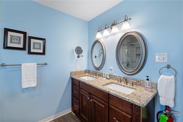 616 Sandcastle Dr, Port Aransas, TX 78373 - full bathroom with wood finished floors, baseboards, double vanity, and a shower