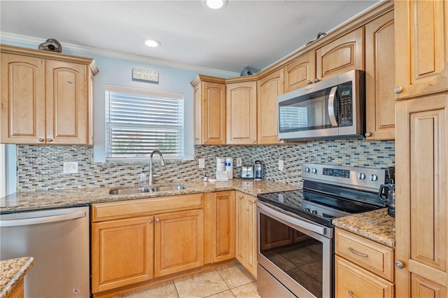 616 Sandcastle Dr, Port Aransas, TX 78373 - kitchen featuring appliances with stainless steel finishes, a sink, light brown cabinets, light stone counters, and decorative backsplash