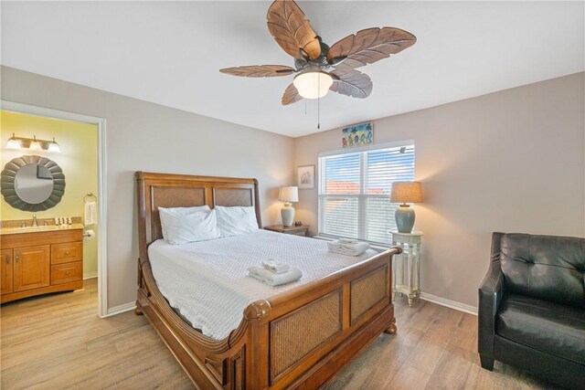 616 Sandcastle Dr, Port Aransas, TX 78373 - bedroom with light wood-style flooring, baseboards, a sink, a ceiling fan, and ensuite bathroom