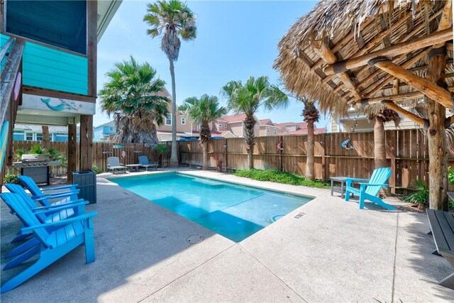 616 Sandcastle Dr, Port Aransas, TX 78373 - view of swimming pool with a patio area, grilling area, a fenced backyard, and a residential view