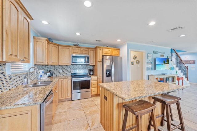 616 Sandcastle Dr, Port Aransas, TX 78373 - kitchen with appliances with stainless steel finishes, a sink, ornamental molding, tasteful backsplash, and light stone counters
