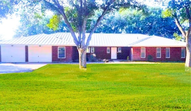 112 Fm 1042, Three Rivers, TX 78071 - ranch-style home featuring driveway, brick siding, a front lawn, a garage, and a metal roof