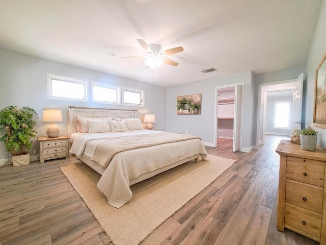 112 Fm 1042, Three Rivers, TX 78071 - bedroom featuring multiple windows, light wood finished floors, a ceiling fan, and a spacious closet