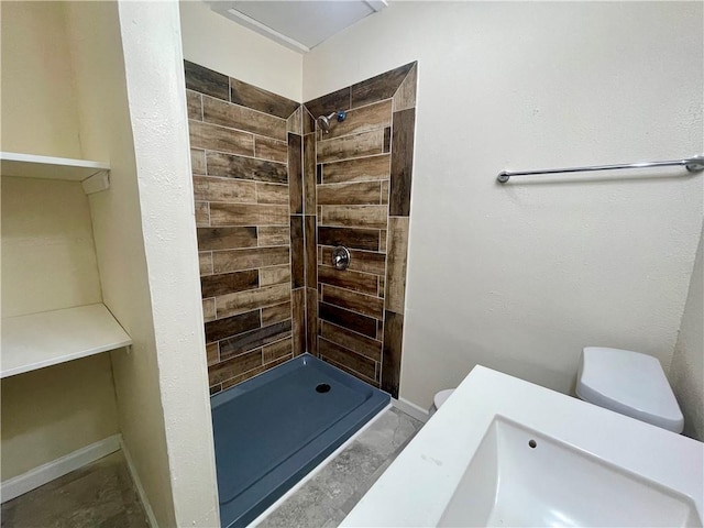 bathroom featuring a tile shower and toilet