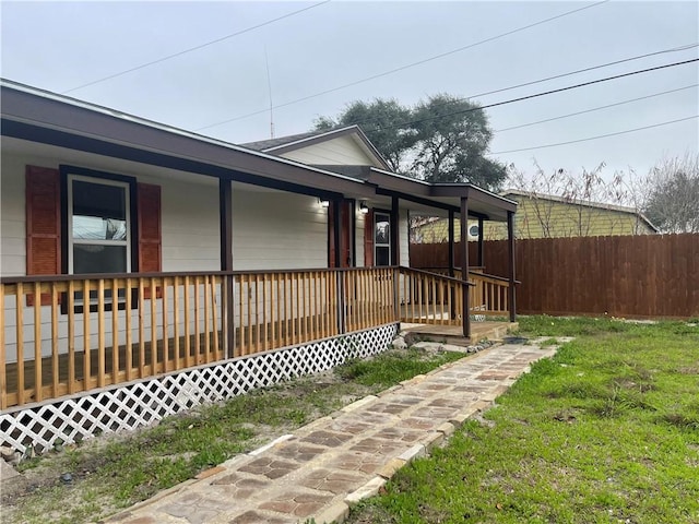 view of side of home featuring a yard and covered porch