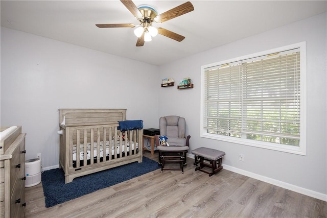 537 Vista Dr, Odem, TX 78370 - bedroom featuring wood finished floors, a crib, baseboards, and a ceiling fan