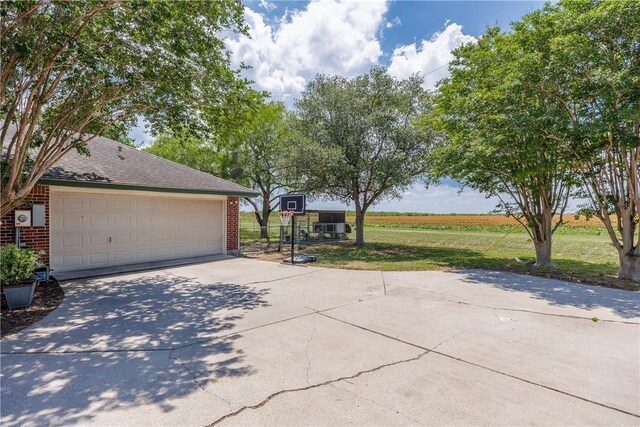537 Vista Dr, Odem, TX 78370 - view of home's exterior with brick siding, concrete driveway, a lawn, and a shingled roof