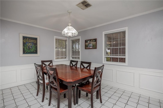 537 Vista Dr, Odem, TX 78370 - dining room with a chandelier, light floors, crown molding, a wainscoted wall, and a decorative wall