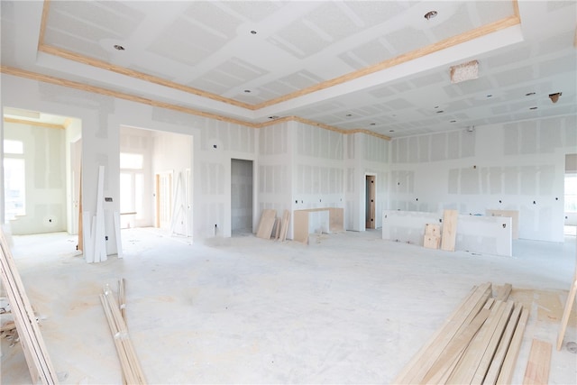 spare room featuring a tray ceiling, a wealth of natural light, a towering ceiling, and ornamental molding