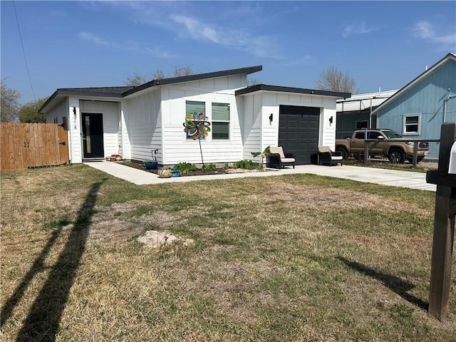 view of front of house with a front lawn, fence, board and batten siding, concrete driveway, and an attached garage