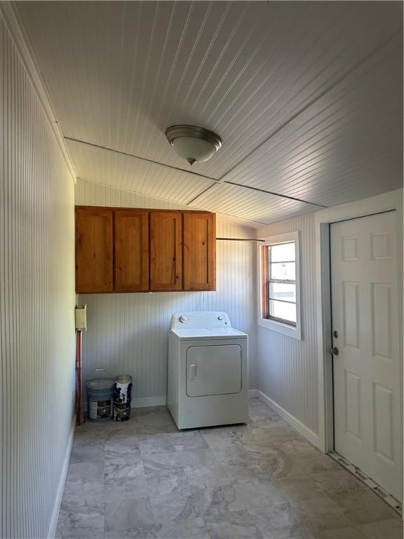 laundry area featuring wood ceiling, washer / dryer, cabinet space, and baseboards