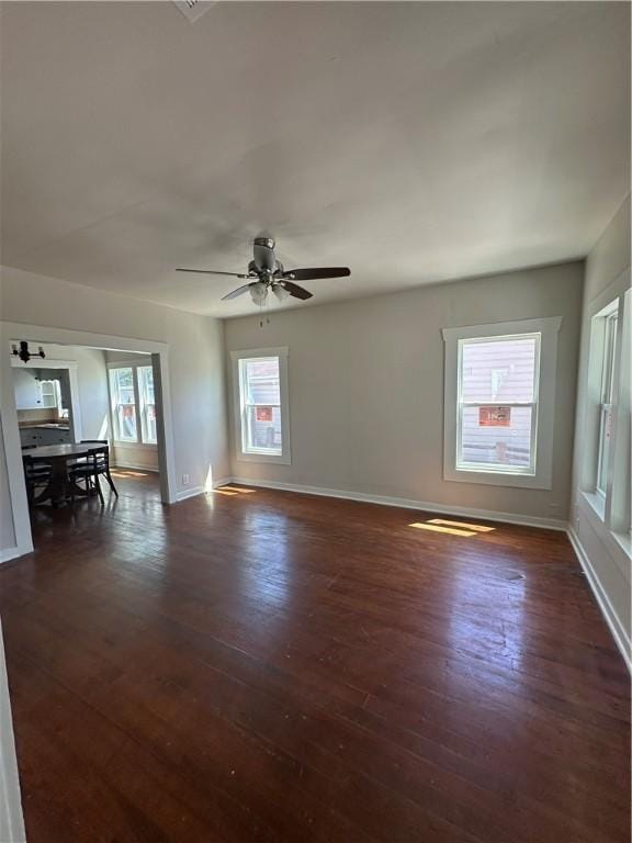 interior space with baseboards, dark wood-style floors, and ceiling fan