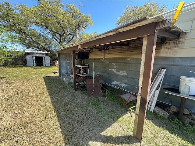 view of outdoor structure featuring fence and an outbuilding