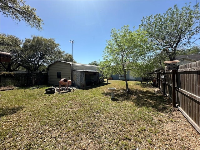 view of yard with a fenced backyard, an outdoor structure, and a storage unit