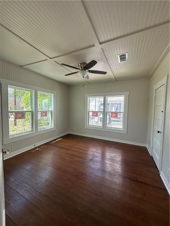 spare room with visible vents, a ceiling fan, baseboards, and dark wood-style flooring