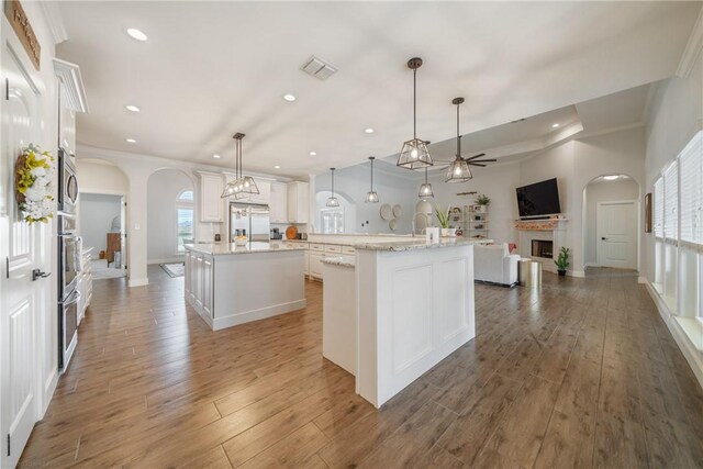 641 Hyacinth Dr, Corpus Christi, TX 78413 - kitchen featuring arched walkways, a center island with sink, ceiling fan, a fireplace, and recessed lighting