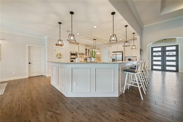 641 Hyacinth Dr, Corpus Christi, TX 78413 - kitchen featuring stainless steel appliances, white cabinets, ornamental molding, light stone countertops, and dark wood-type flooring