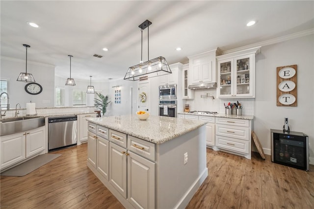 641 Hyacinth Dr, Corpus Christi, TX 78413 - kitchen featuring appliances with stainless steel finishes, a sink, under cabinet range hood, white cabinetry, and recessed lighting