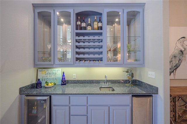 bar featuring dark stone counters, sink, and wine cooler