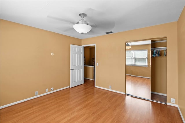 unfurnished bedroom featuring a closet, light hardwood / wood-style flooring, and ceiling fan