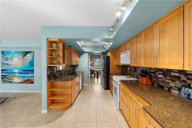 kitchen featuring backsplash, sink, light tile patterned floors, and white appliances