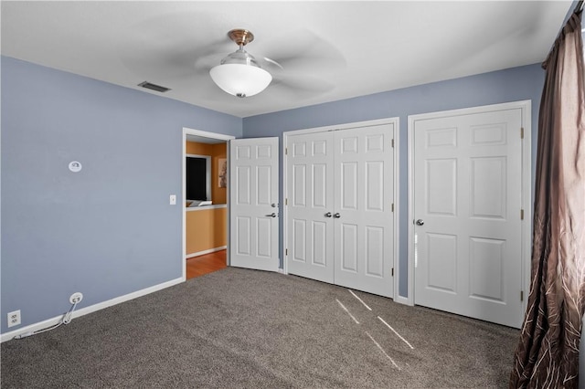 unfurnished bedroom with dark colored carpet and ceiling fan