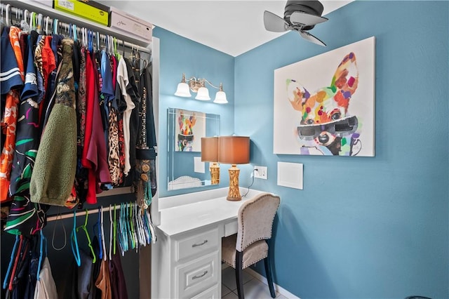 tiled office space featuring ceiling fan and built in desk