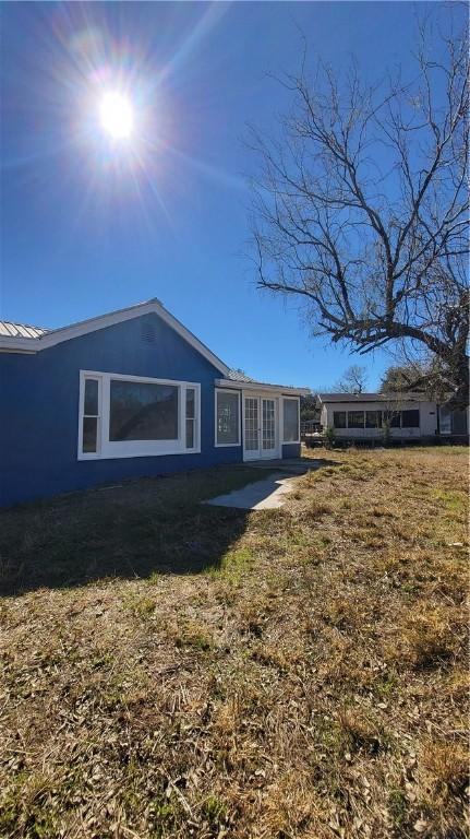 rear view of property featuring a lawn