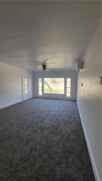 carpeted empty room with a healthy amount of sunlight, ceiling fan, and a wall mounted AC