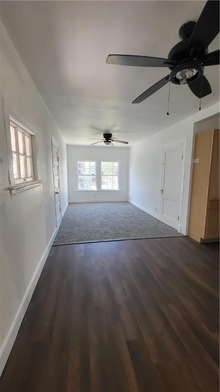 unfurnished living room with ceiling fan and dark hardwood / wood-style flooring