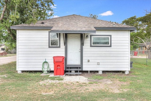 rear view of property featuring a yard