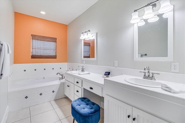 bathroom featuring vanity, a relaxing tiled tub, and tile patterned floors