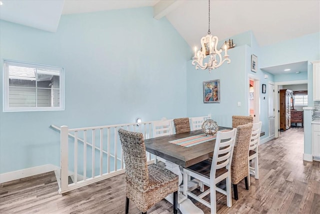 dining room with wood-type flooring, beam ceiling, a chandelier, and high vaulted ceiling