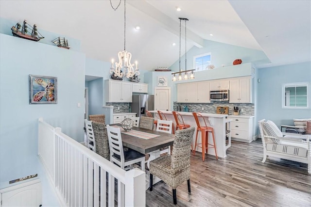 dining room with beamed ceiling, an inviting chandelier, high vaulted ceiling, and hardwood / wood-style floors