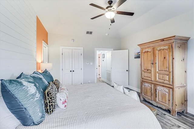 bedroom with lofted ceiling, light hardwood / wood-style floors, a closet, and ceiling fan