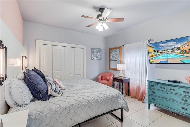 tiled bedroom with ceiling fan and a closet