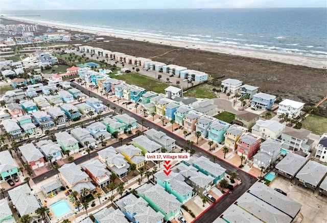 birds eye view of property with a water view and a beach view