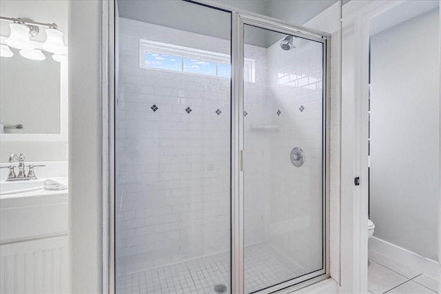 bathroom featuring tile patterned flooring, vanity, a shower with door, and toilet