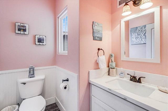 bathroom featuring vanity, hardwood / wood-style floors, and toilet