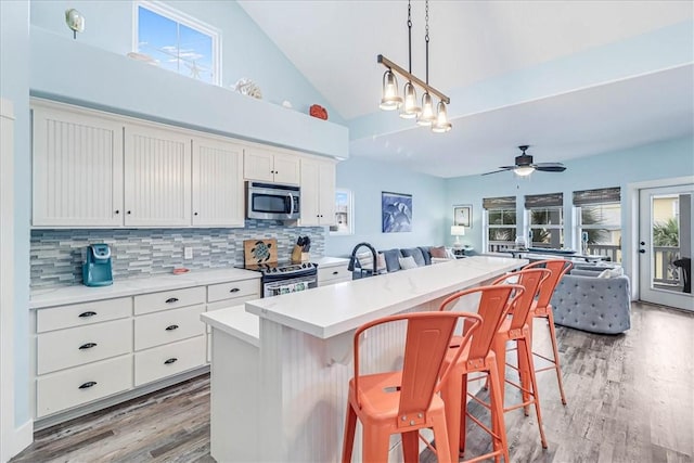 kitchen with tasteful backsplash, stainless steel appliances, a kitchen breakfast bar, and a center island