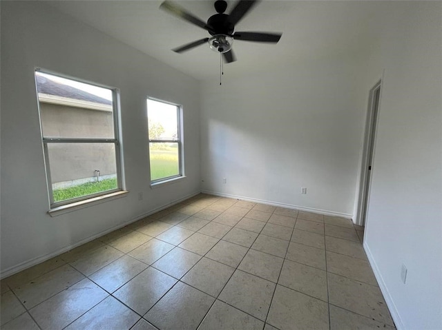 tiled spare room with ceiling fan