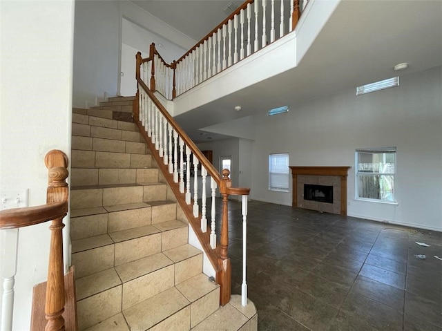 stairway featuring a fireplace and a high ceiling