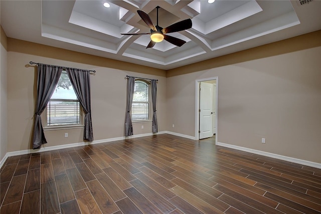 empty room featuring a raised ceiling, ceiling fan, dark hardwood / wood-style flooring, and coffered ceiling