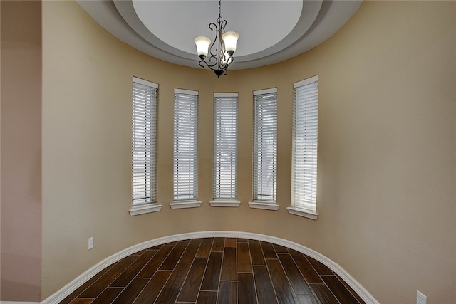 unfurnished room with hardwood / wood-style floors and a notable chandelier