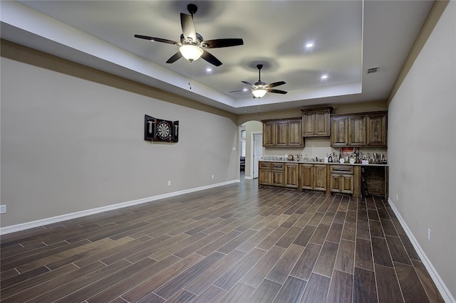 kitchen with a tray ceiling, ceiling fan, and dark hardwood / wood-style floors